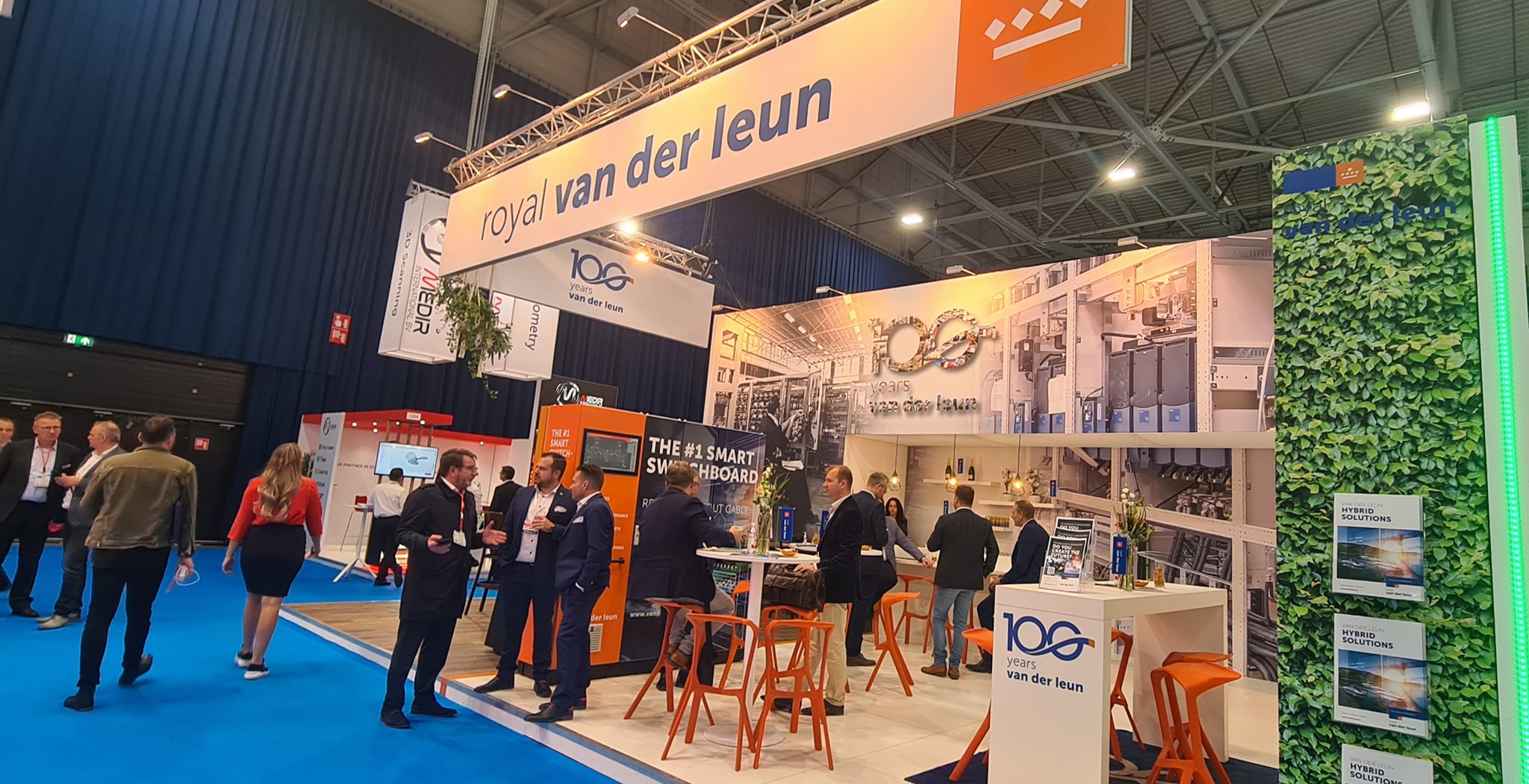 royal-van-der-leun-europort-2021-stand-1320-bezoekers-en-gasten-en-stand-personeel-oranje-en-blauwe-uitstraling-100-jarig-bestaan-hybrid-solutions